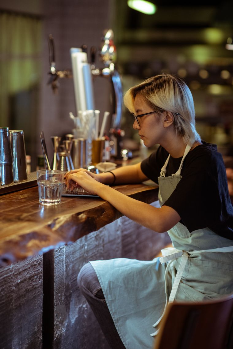 Restaurant staff member using a laptop