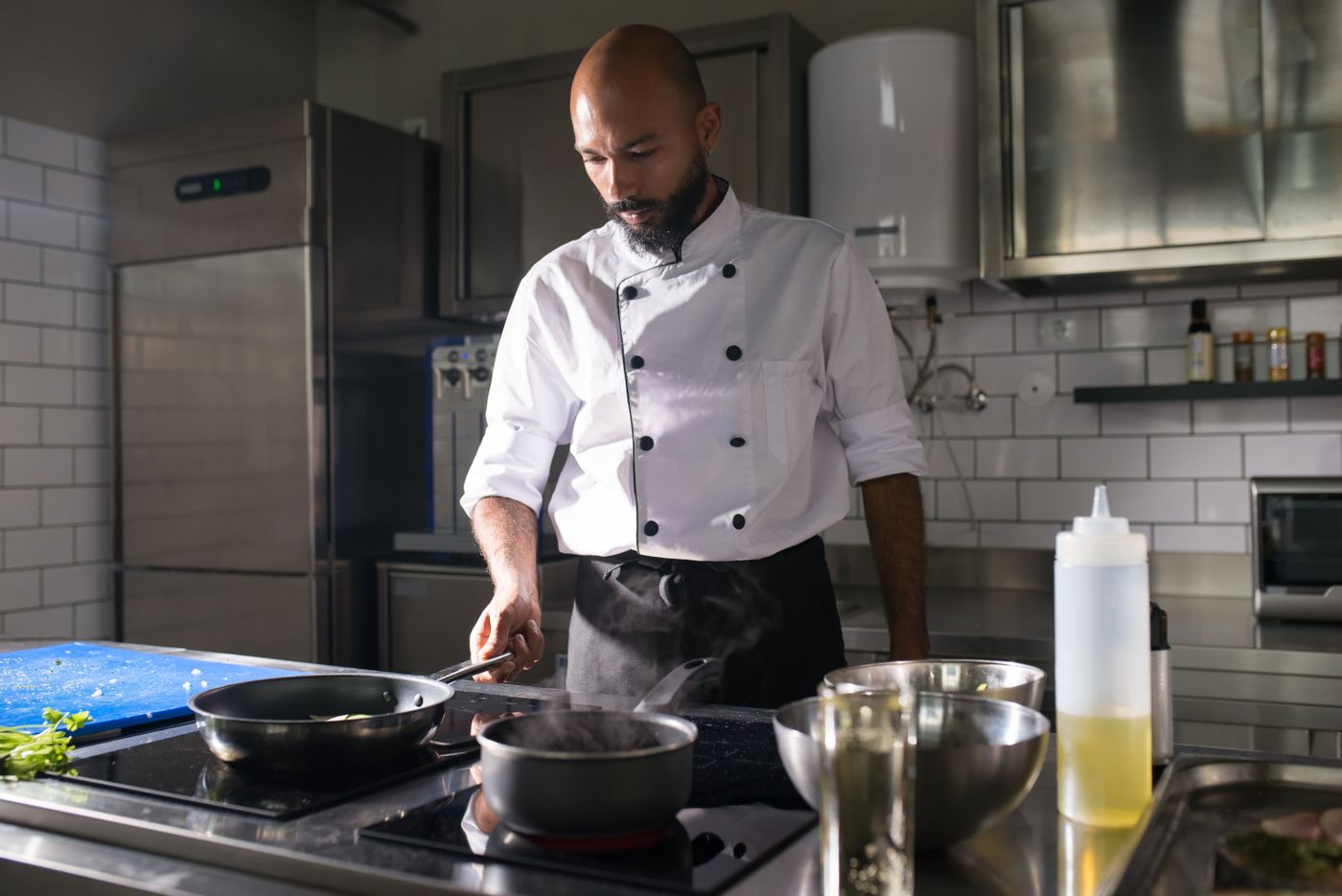 Man in white chef uniform cooking in the kitchen